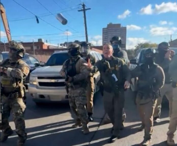 Border Patrol leader Greg Bovino tossing tear gas into a crowd of protesters last month. (Screen grab)