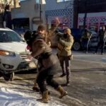 Alex Pretti, one hand on his phone, one hand in the air.