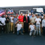 Trump poses with the crew that helped line the Reflecting Pool basin, on May 7. Trump also drove his motorcade over the new coating.