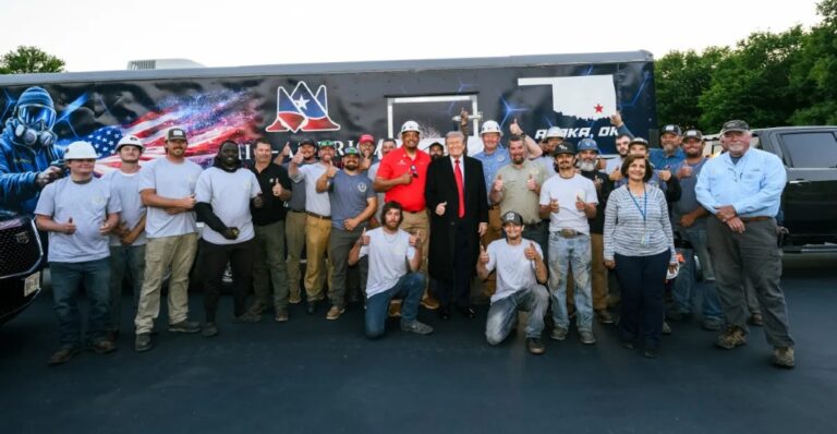 Trump poses with the crew that helped line the Reflecting Pool basin, on May 7. Trump also drove his motorcade over the new coating.